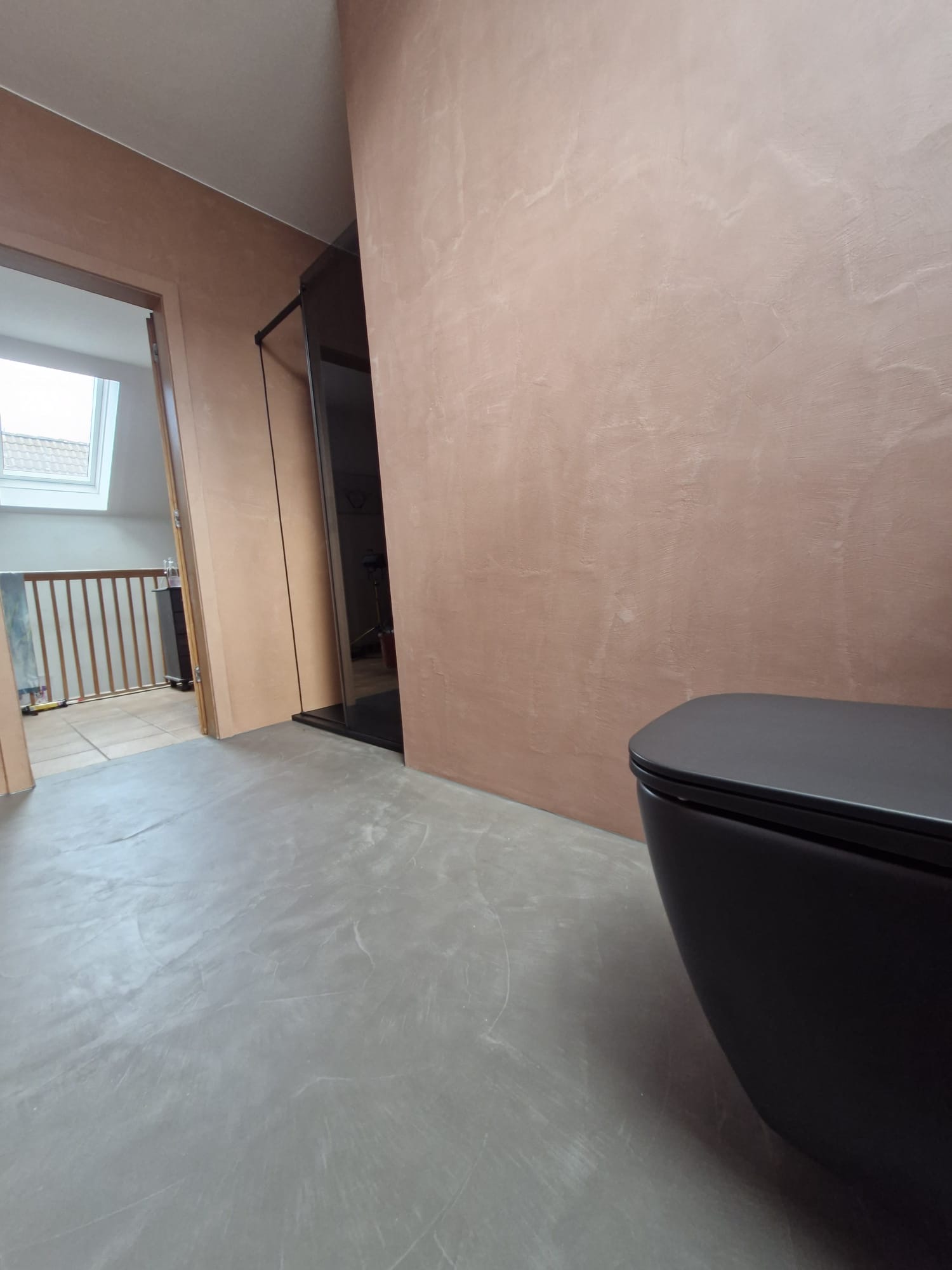 Badezimmer mit fugenlosen Wänden in rosiger Betonoptik