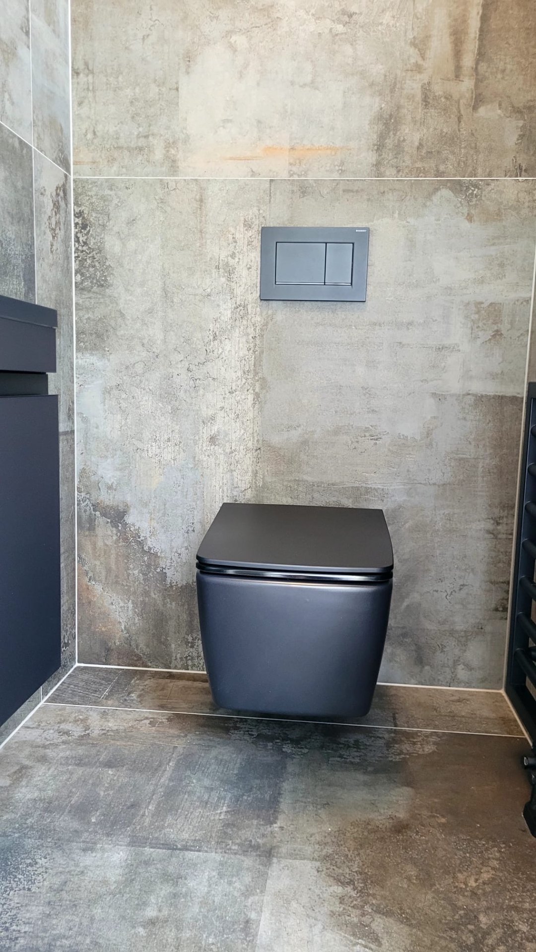 WC mit grauen Fliesen in Betonoptik